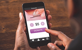 A person using a smartphone to make a $5 donation, highlighting the ease of online giving for nonprofit support.
